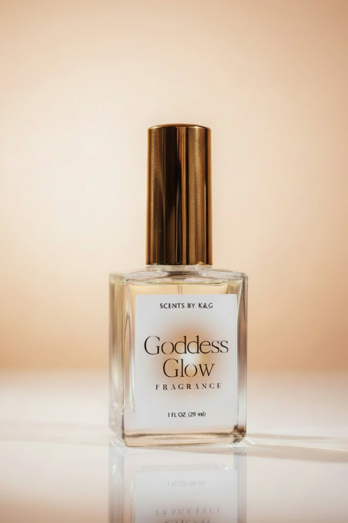 A bottle of Goddess Glow Fragrance by Scents by K&G, featuring a clear glass bottle with a metallic gold cap and a white label, set against a warm beige gradient background.