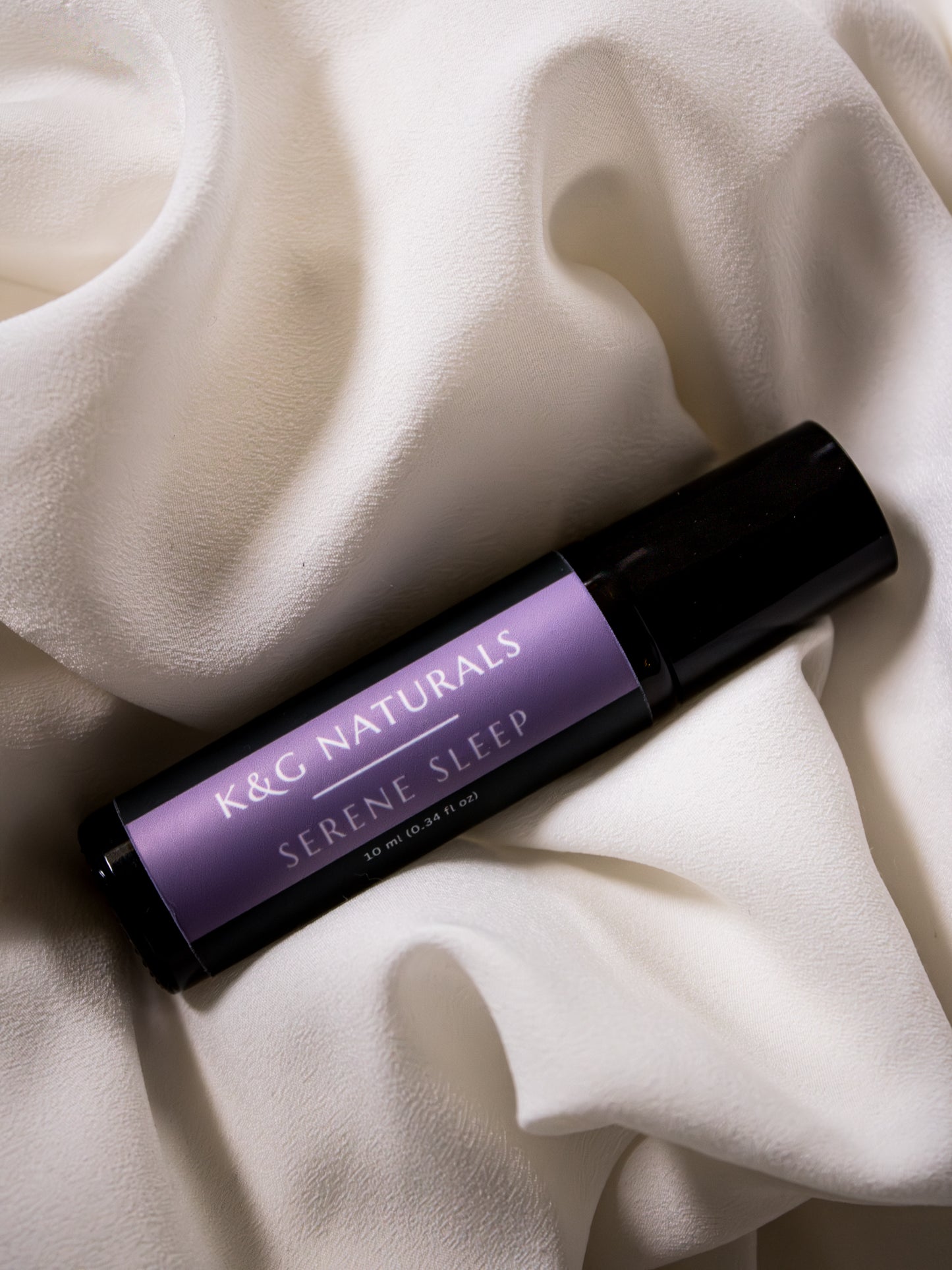 K&G Naturals Serene Sleep rollerball on a soft white fabric background