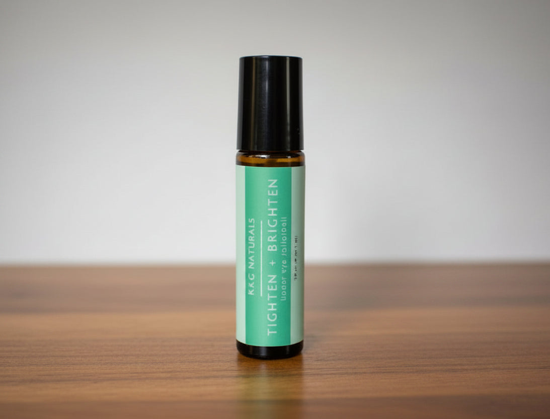 A 'Tighten and Brighten' under eye rollerball by K&G Naturals on a wood surface