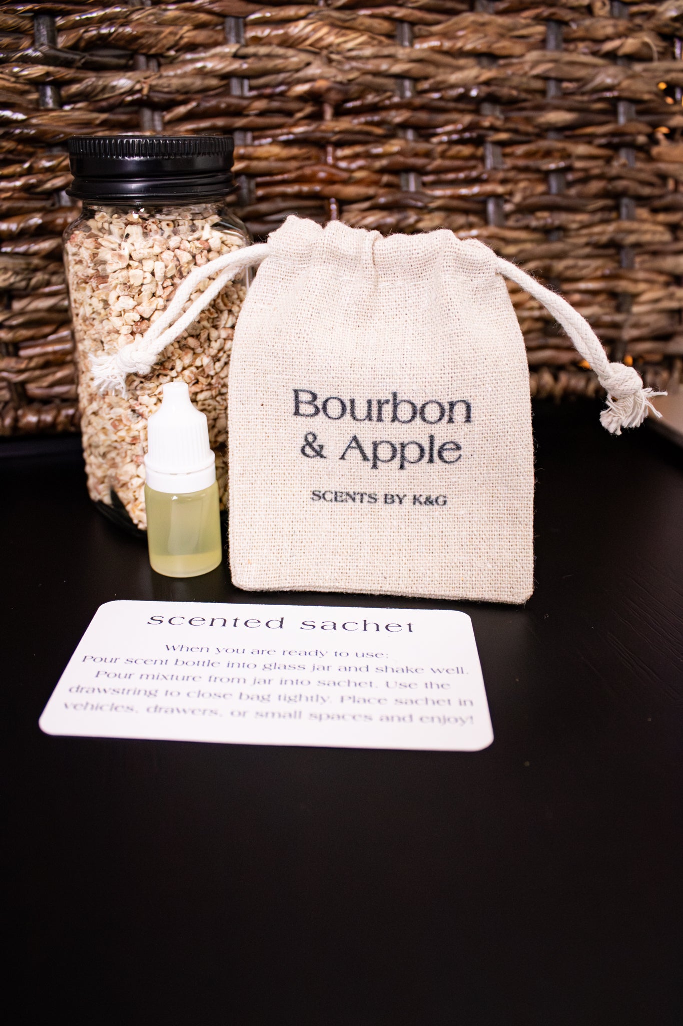 Scented sachet with bottle and packaging labeled 'Bourbon & Apple' by Scents by K&G on a dark surface.