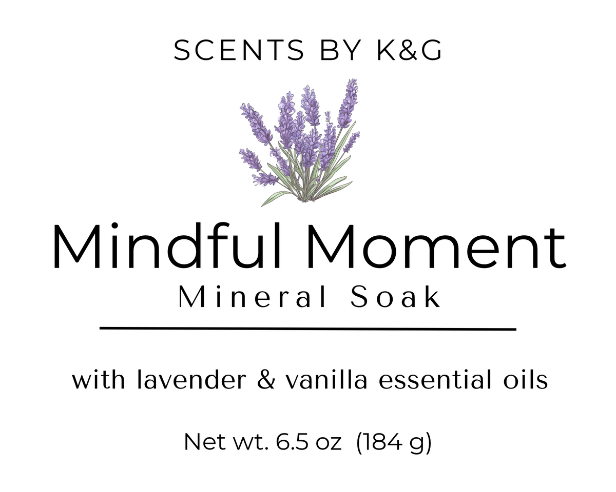 Product label for Scents by K&G's 'Mindful Moment' Mineral Soak, featuring a lavender illustration on a white background with black text detailing the lavender and vanilla essential oils and 6.5 oz net weight.