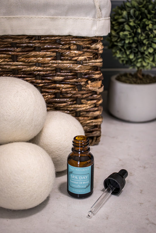 K&G Naturals Spa Day Blend wool dryer ball dropper bottle next to wool dryer balls