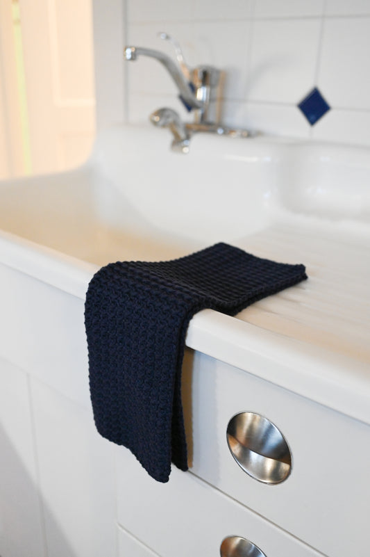 A dark blue kitchen towel on a white countertop.